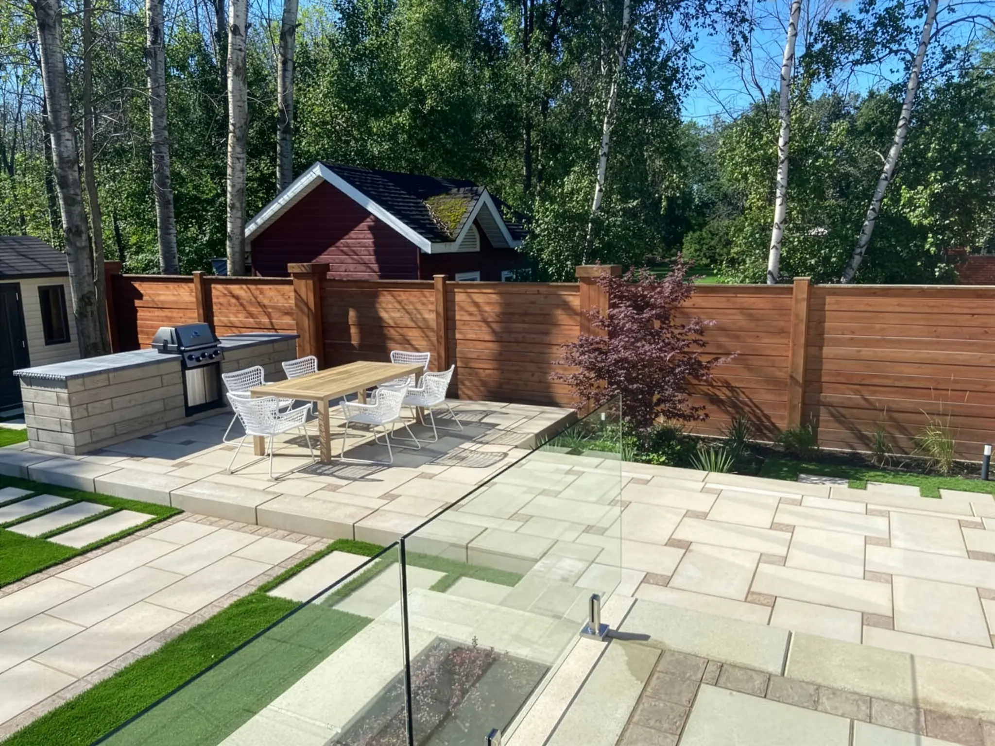 Espace repas extérieur sur pavé uni avec cuisine BBQ intégrée et clôture en cèdre, Rive-Sud