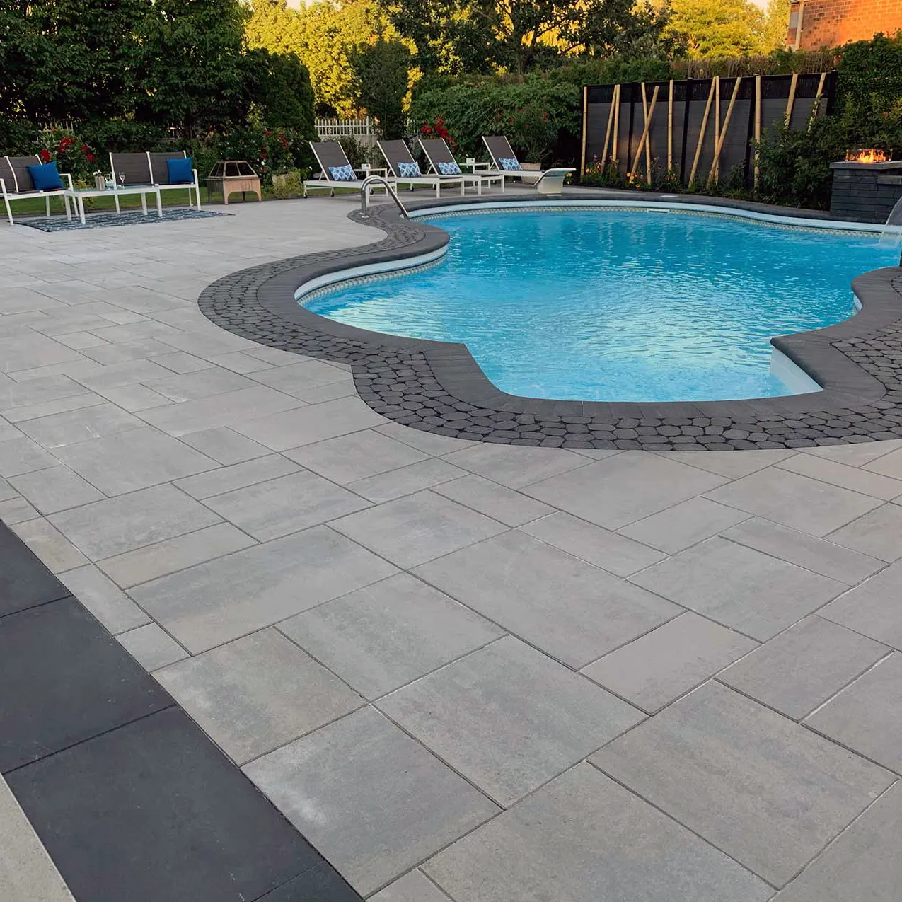 terrassement-pave-piscine-rive-sud Terrassement et pavé uni autour d’une piscine creusée avec contours arrondis, aménagement extérieur sur la Rive-Sud de Montréal